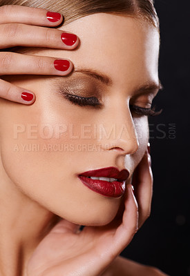 Buy stock photo Face, makeup and woman for beauty, hand for manicure and red nail polish, lipstick and eyeshadow with lashes on black background. Skin, foundation and shine, color for cosmetics and glamour in studio