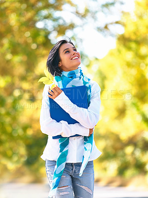 Buy stock photo A young woman strolling down the street admiring the autumn leaves