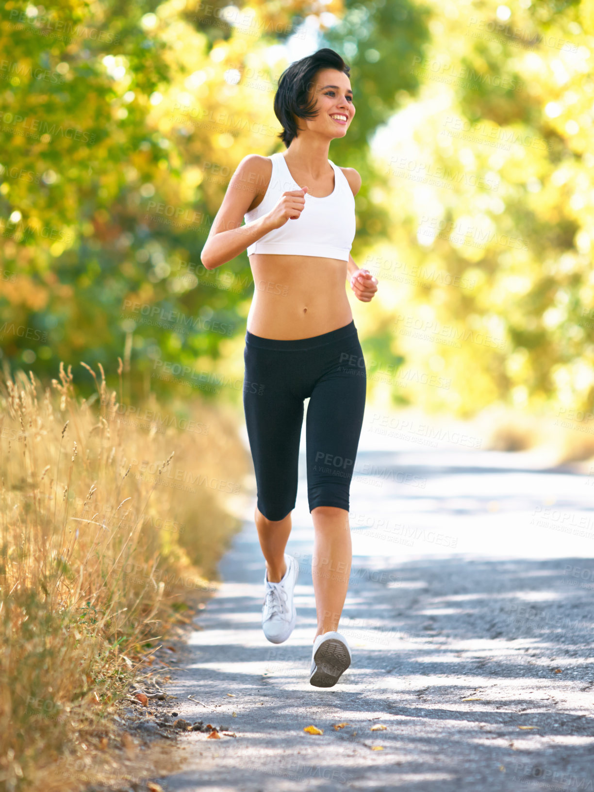 Buy stock photo Woman is running in road, sport and fitness outdoor with fit body, healthy and active person. Cardio, exercise and training for race, young female runner in nature with workout for health