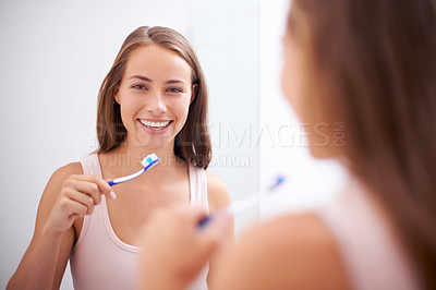 Buy stock photo A young woman brushing her teeth