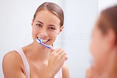 Buy stock photo A young woman brushing her teeth