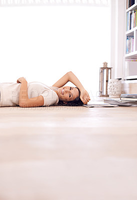 Buy stock photo Portrait of an attractive young woman lying on the floor of her home