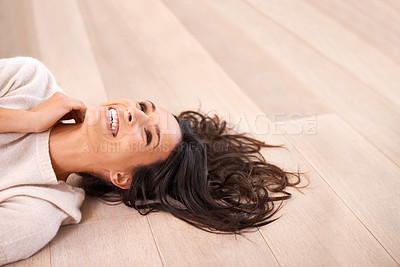 Buy stock photo Studio shot of a beautiful young woman relaxing on a wooden floor