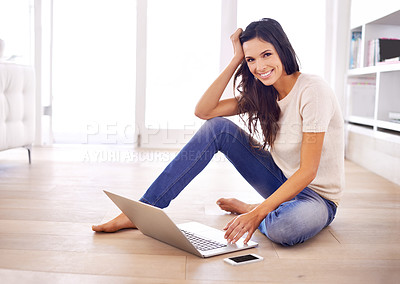 Buy stock photo A young woman sitting on the floor with her laptop