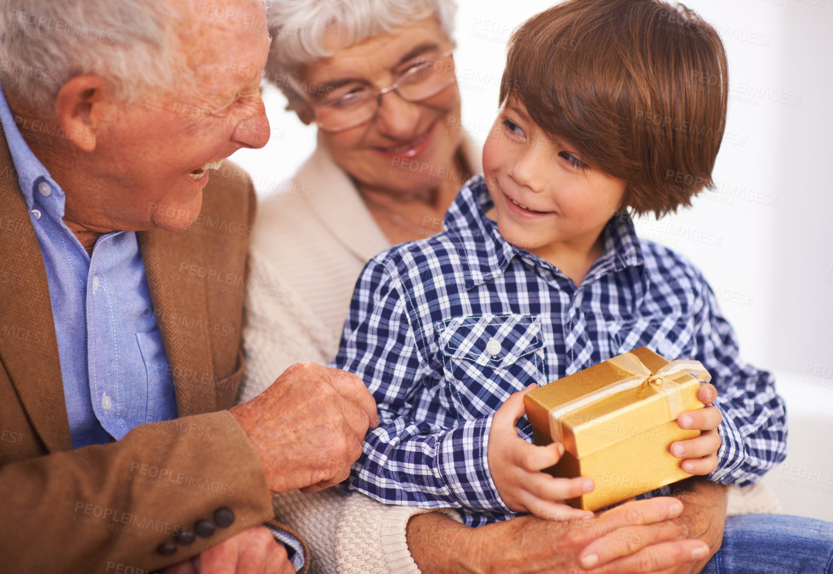 Buy stock photo A young boy getting a gift from his grandparents