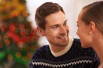 Buy stock photo Happy, conversation and couple on a date on Christmas for romantic, holidays and love bonding. Smile, care and young man and woman talking in living room with xmas festive decoration at home.