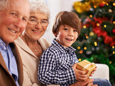 Buy stock photo Grandparents, child and Christmas gift as portrait for festive season celebration for tradition, presents or bonding. Elderly couple, boy and present box in home in Canada for vacation, love or happy
