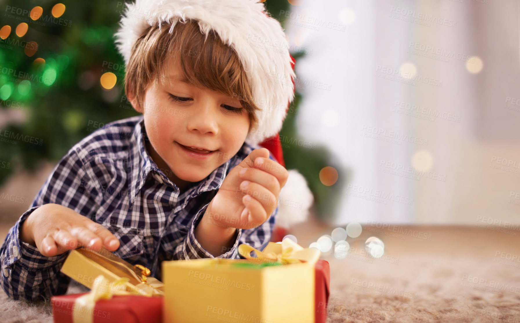 Buy stock photo A young boy opening a gift on Christmas
