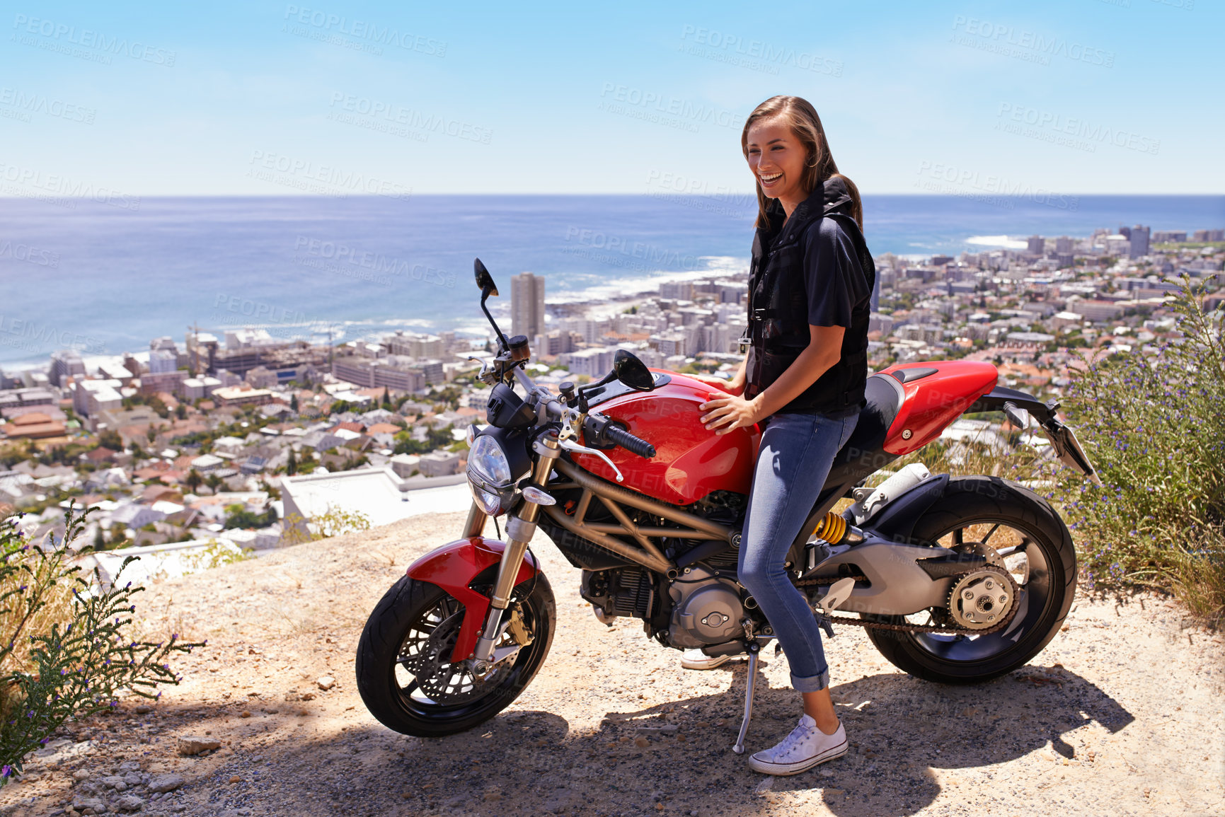 Buy stock photo Happy woman, biker and motorcycle in city by the ocean coast for road trip, travel or outdoor holiday in nature. Female person or rider with smile, bike or transport on cliff or ledge in neighborhood