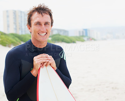 Buy stock photo A surfer posing on the beach with his board alongside copyspace