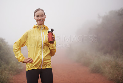 Buy stock photo Nature, fitness and portrait of woman drinking water for running on dirt road with marathon training. Sports, workout and athlete enjoying beverage for hydration on misty outdoor cardio exercise.