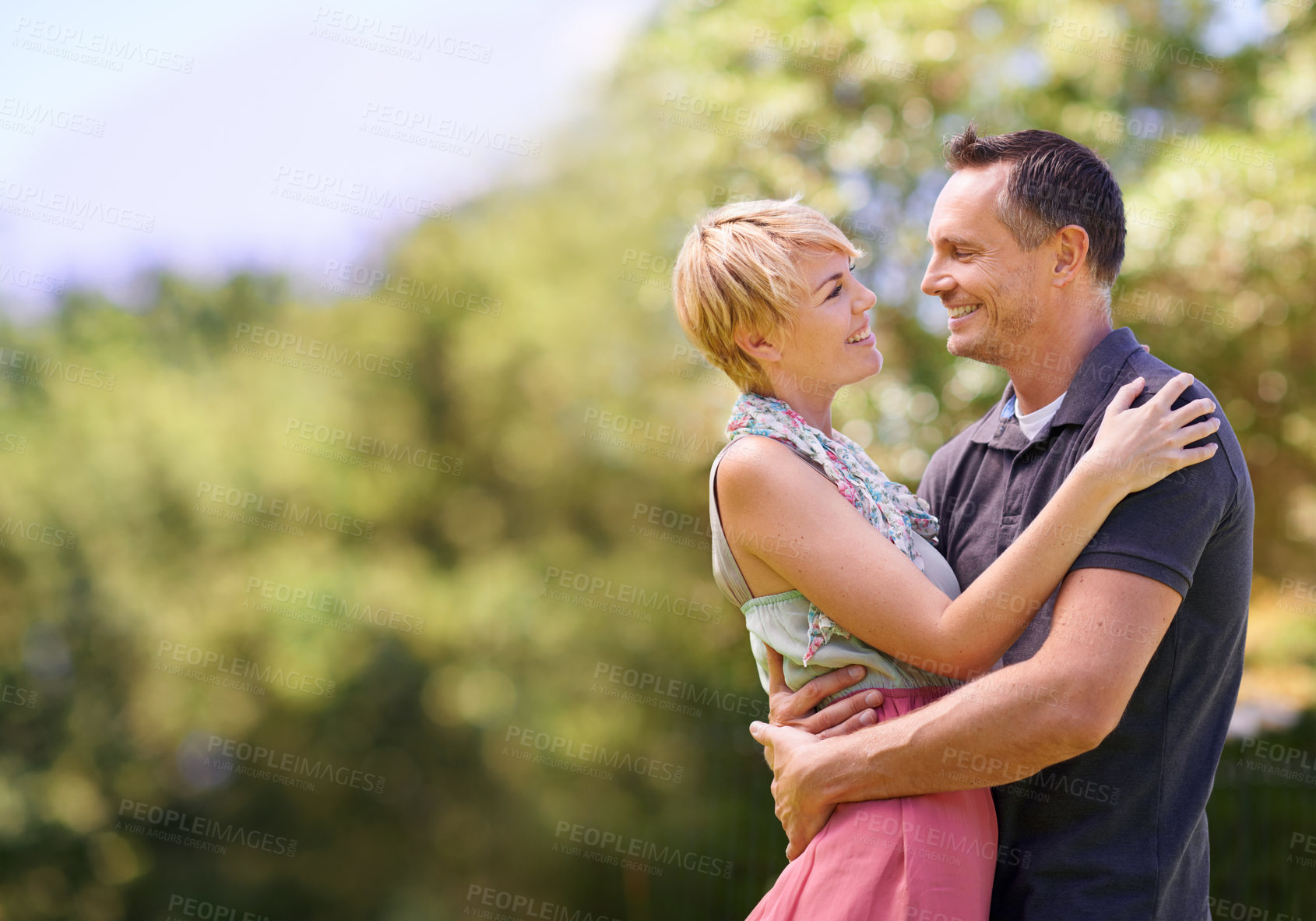 Buy stock photo Love, smile and happy couple hug in park with trust, support or solidarity, security or bonding in nature. Commitment, eye contact or people embrace in forest for spring romance, fun or outdoor date