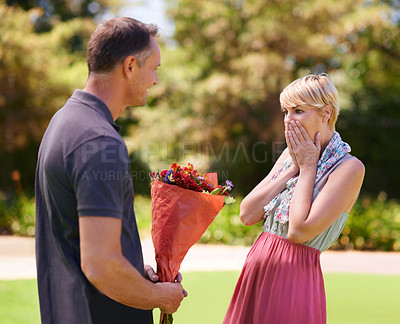 Buy stock photo Shot of a mature woman surprised by a bouquet of flowers from her husband