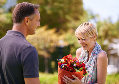 Buy stock photo Smile, couple and gift of flowers outdoor in nature, bonding and date on valentines day. Bouquet, man and woman with floral present for love, care and romantic connection of people at garden together