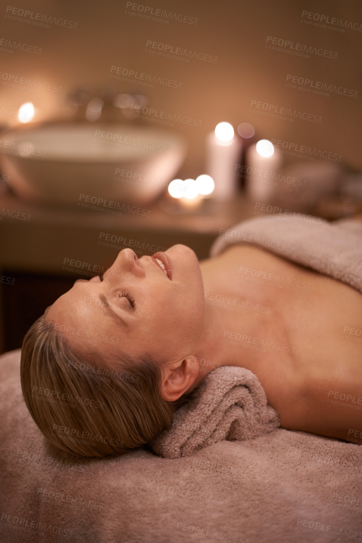 Buy stock photo Blonde woman, massage therapy and candlelight for wellness, smile and relaxation to destress and pamper. Female person, self care and cleanse for detox, spa day and peace for beauty and happiness