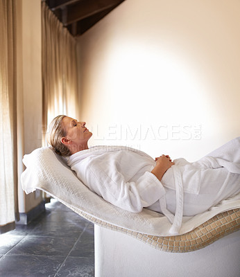 Buy stock photo Woman, lying and relax for wellness, spa and healthy weekend getaway at luxury retreat in Amsterdam. Peaceful, holistic and rest for female person on table with robe, eyes closed and calm expression