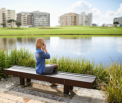 Buy stock photo Phone call, park and woman on bench in city for communication, social networking and chat outdoors. Relax, happy and person on smartphone for talking, conversation and speaking by lake on weekend