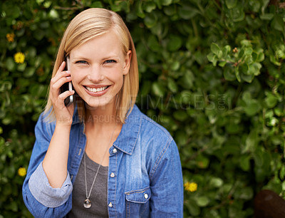 Buy stock photo Cropped shot of an attractive blonde woman talking on her phone in the park