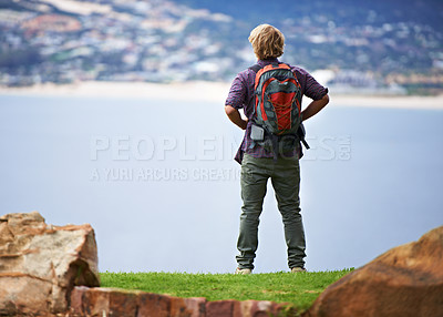 Buy stock photo Person, hiking and back on mountains for fitness, outdoor and wellness in nature with cityscape in Europe. A hiker with backpack for trekking, journey and adventure or travel on a hill by an ocean