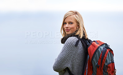 Buy stock photo Woman, hiking and portrait for travel, adventure and wellness on a cloudy sky or grey background in winter. Face of a young person in backpack for trekking, explore or journey outdoor with mockup