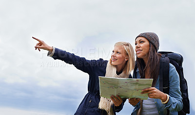 Buy stock photo Woman, friends and pointing with map for direction or location on hiking adventure together in nature. Young female person, hiker or team with travel guide for destination, route or outdoor path