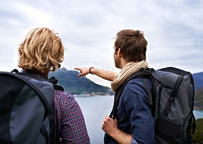 Buy stock photo Man, friends and backpack for hiking by ocean in travel, sightseeing or outdoor journey in nature. Rear view of male person or hikers with bag on back for trekking, fitness or adventure by cloudy sky