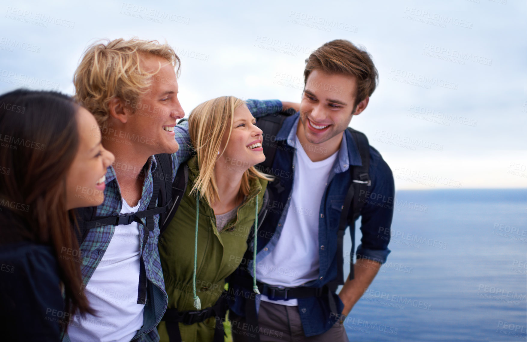 Buy stock photo Friends, group and happy on by ocean for hiking, adventure and talking of eco friendly tourism, travel and sightseeing. Young people with backpack and excited to explore, trekking or outdoor journey 