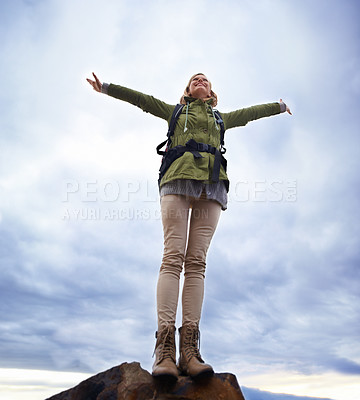 Buy stock photo Woman, hiking and freedom on mountain top for travel, success and achievement or fresh air on cloudy sky. Young person in backpack and stretching arms for trekking, journey or adventure in low angle