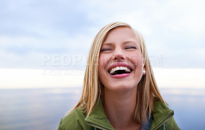 Buy stock photo Woman, excited and happy at the beach for holiday, vacation and travel in winter. Face of a young person in the USA laughing and smile by an ocean, sea or lake with cloudy sky for outdoor adventure