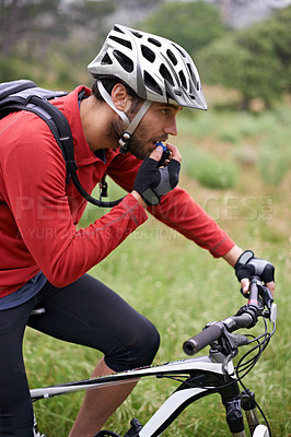 Buy stock photo Fitness, cycling and drinking water with man in countryside for adventure, discovery or off road sports hobby. Exercise, health and hydration with young athlete on bike for cardio training or workout