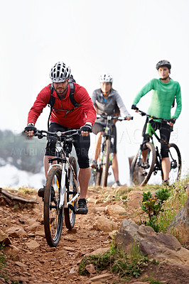 Buy stock photo A group of young cyclists riding a along a rocky trail