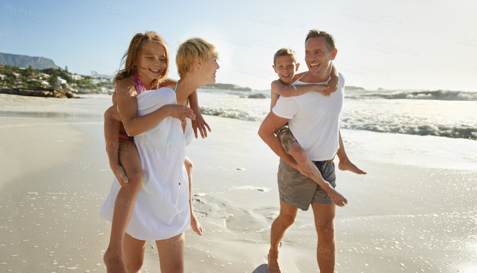 Buy stock photo Beach, family walk and piggyback with laughing mother, father and kids together outdoor in nature travel. Sea, smile or happiness with bonding, parent support and love walking by the ocean on holiday