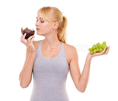 Buy stock photo Woman, temptation and dessert over fruit in studio with white background in backdrop. Girl, choice and decision between muffin or grapes for nutrition in food, think and care for wellness of body