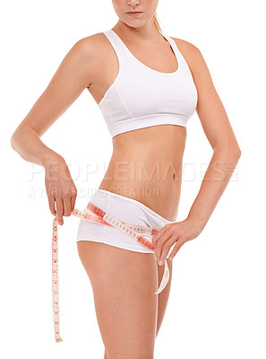 Buy stock photo Measuring tape, fitness and body of woman in studio for diet, workout or weight loss results. Health, wellness and closeup of female person with tool to measure hips or butt by white background.