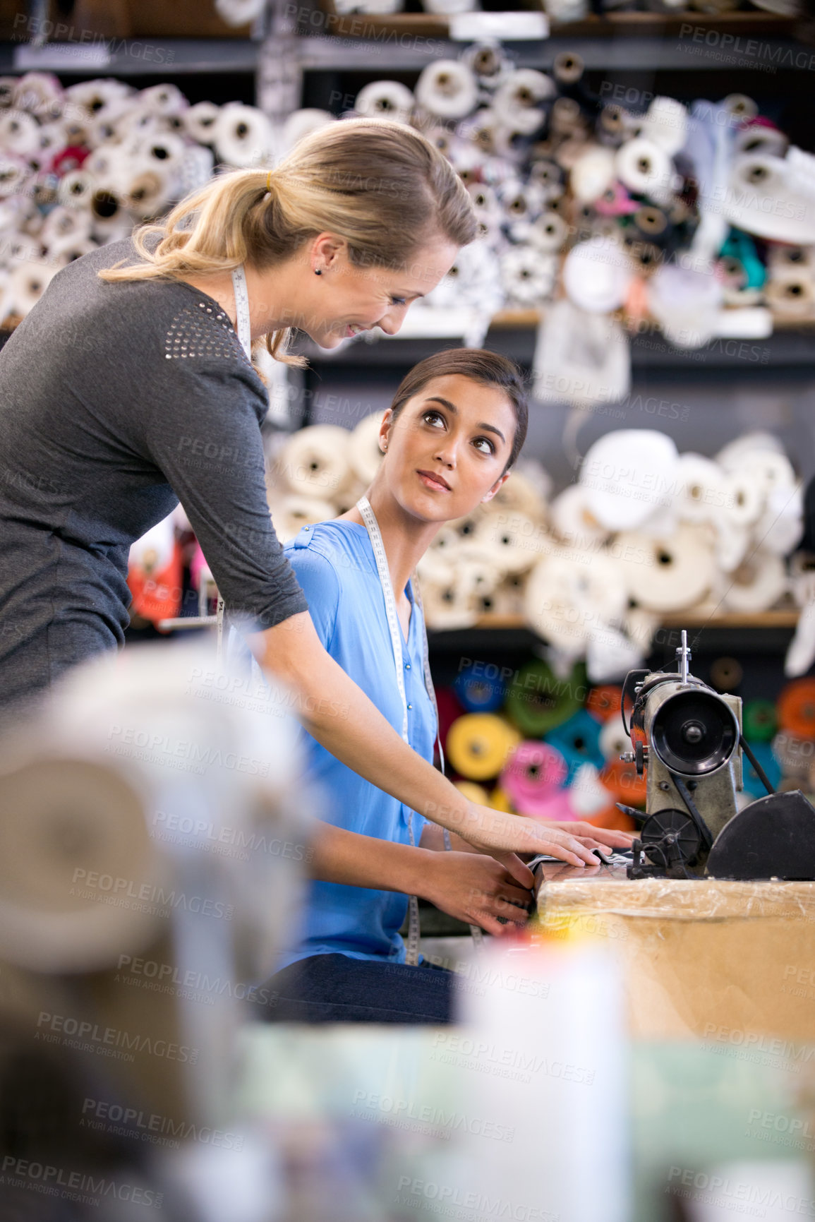 Buy stock photo Sewing, machine and training woman in workshop, learning to work with fabric and process in fashion. Tailor, mentoring or help manufacturing clothes in small business with teamwork in factory