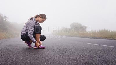 Buy stock photo Shot of a young woman getting ready for a run
