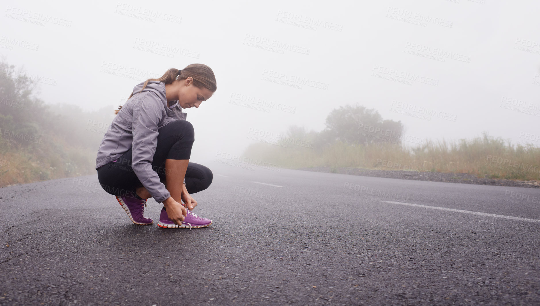Buy stock photo Shot of a young woman getting ready for a run