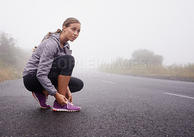 Buy stock photo Fitness, woman and tie shoes on road outdoor to prepare for exercise, training or workout with fog in winter. Sports, serious person and tying sneakers, thinking and getting ready on mockup space