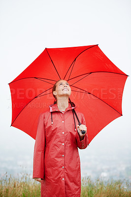 Buy stock photo Rain, happy and red umbrella with woman in nature for winter, storm and carefree. Happiness, weather and cold with female wearing raincoat in outdoor for waterproof, cloudy and protection