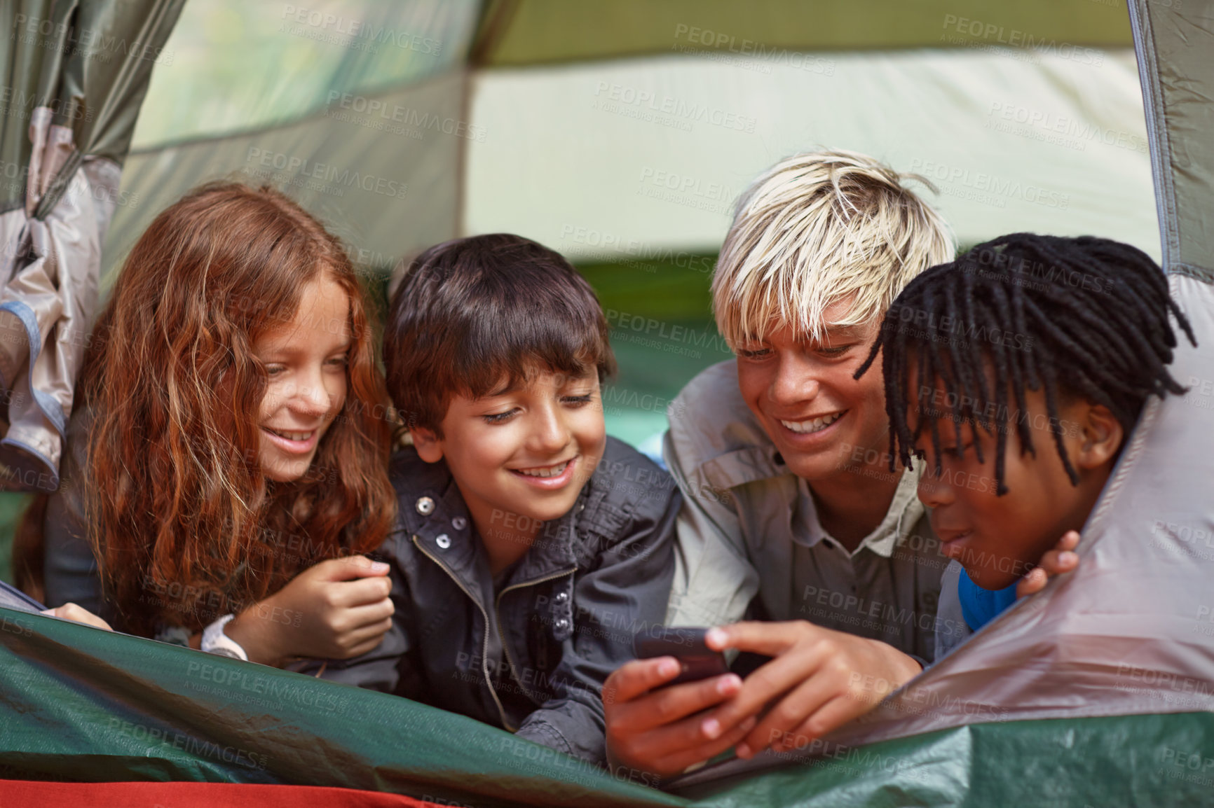 Buy stock photo Phone, happy and children in tent for camp networking on social media, mobile app or internet. Smile, technology and young kids bonding, relax and streaming video online with cellphone on vacation.