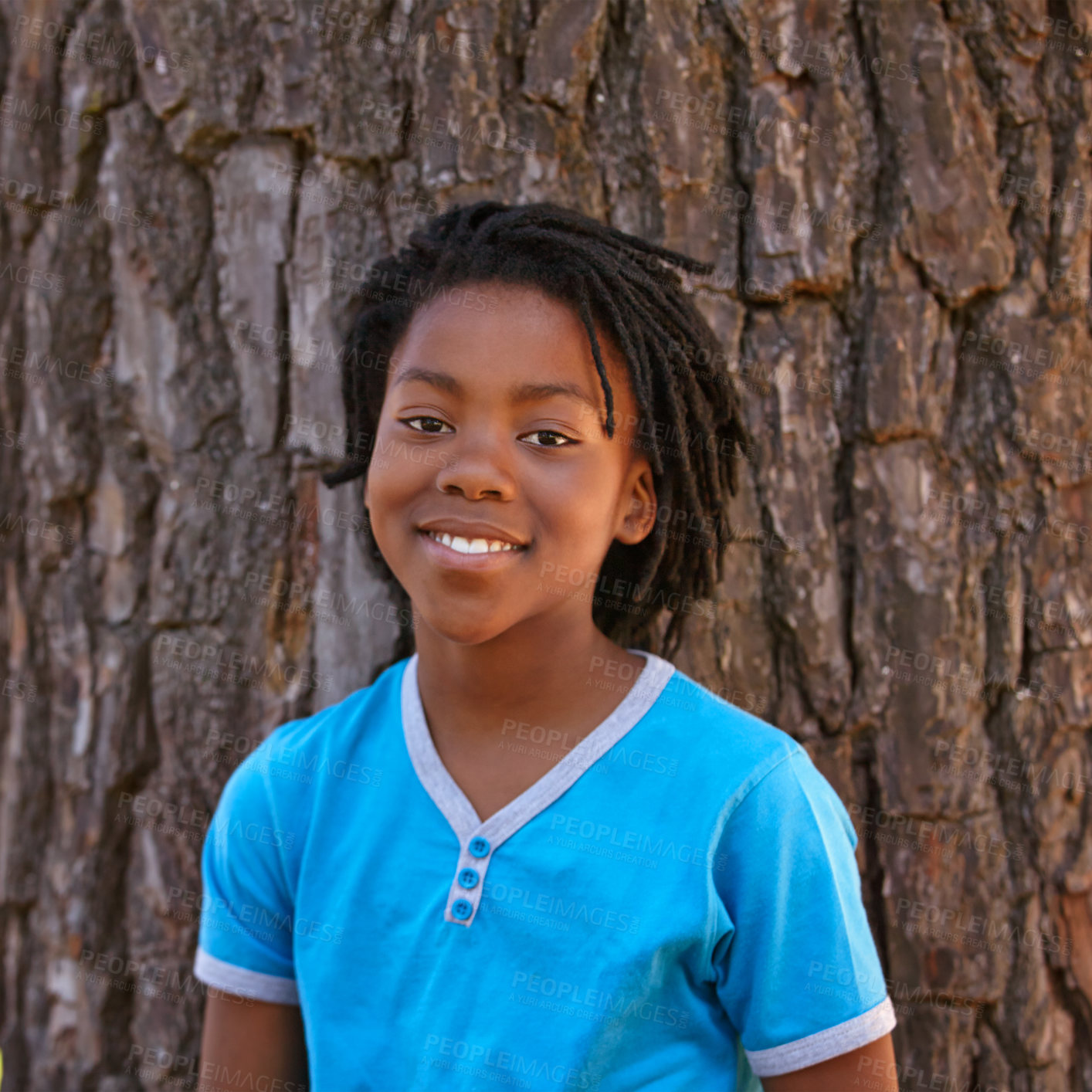 Buy stock photo Happy portrait, black child and tree in fashion, hairstyle or childhood for outdoor nature. Face of young African, male person or teenager with smile, blue tshirt or casual clothing by bark or forest