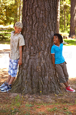 Buy stock photo Children, friends and nature with hiding, fun and diversity for happiness at summer camp. Kids, smile and adventure with vacation, holiday and green forest or park with tree trunk and positivity