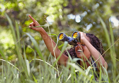 Buy stock photo Nature, binoculars and girl in grass for exploring in park on vacation, adventure or holiday. Travel, forest and young child or kid with equipment in lawn in outdoor field or woods on weekend trip.
