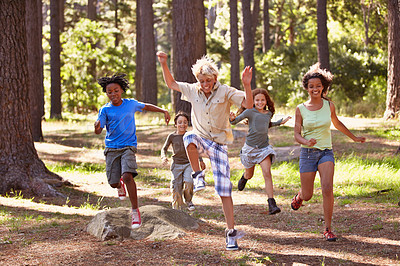 Buy stock photo Shot of a group of young kids enjoying themseves out in the woods