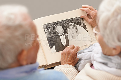 Buy stock photo Shot of a senior couple leafing through their wedding album