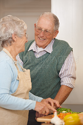 Buy stock photo Senior couple, cutting vegetables and laughing in kitchen, food preparation and love at home. Elderly people, healthy meal and organic ingredients for nutrition, funny conversation and retirement