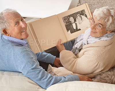 Buy stock photo Senior couple, portrait or looking at photo album together, pictures or memories at home, living room or couch. Elderly people, top view or cheerful on sofa with wedding photographs, happy or smiling