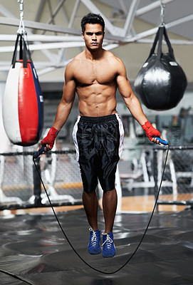 Buy stock photo Portrait, fitness and man skipping in gym for fight preparation, training or boxing cardio. Exercise, workout or strong body of shirtless young athlete with jump rope for combat sports competition