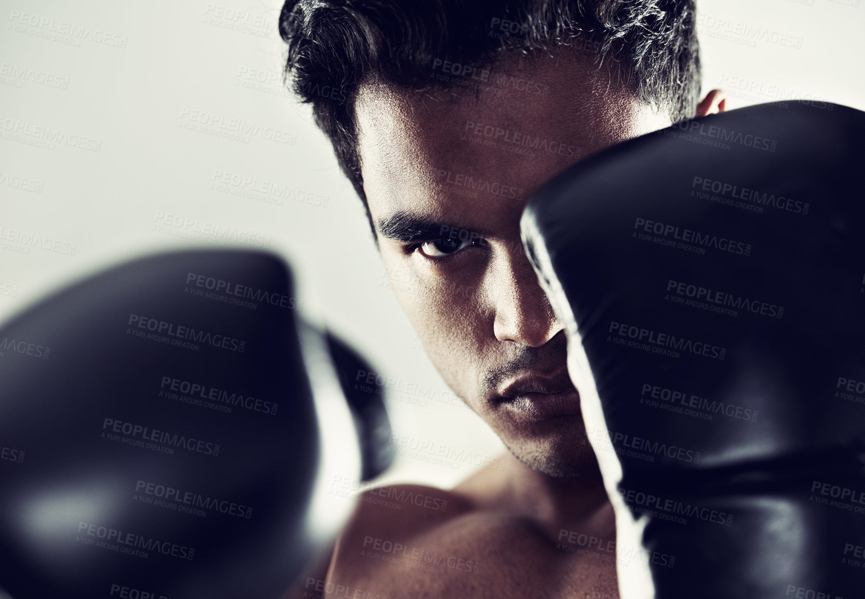 Buy stock photo Portrait, man and boxer in training, exercise and workout for body health isolated on a grey studio background. Fight, serious face and athlete in gloves for fitness, sports and stance in Brazil