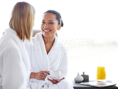 Buy stock photo Two young women having coffee in their bathrobes at the day spa